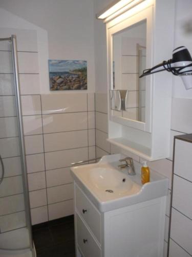 bagno bianco con lavandino e specchio di Fehmarn-OstseeferienFewoMarquardt165 a Burgtiefe auf Fehmarn 
