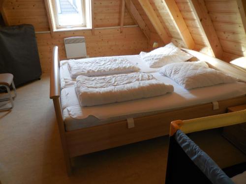 ドルムにあるFerienhaus Klapötkeの木造キャビン内のベッドルーム1室(ベッド2台付)