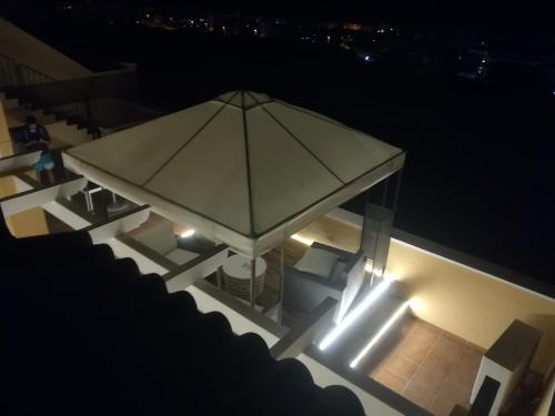 einen Regenschirm auf dem Balkon bei Nacht mit Lichtern in der Unterkunft Penthouse in Casares