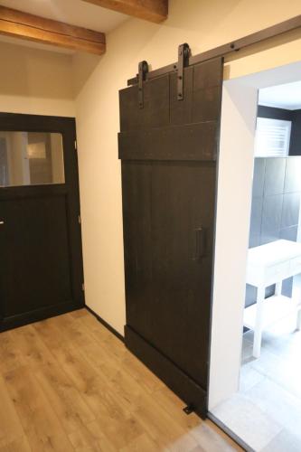 Una gran puerta negra en una habitación con suelo de madera. en BLUMENSTIL Ferienwohnungen 3 en Bad Salzungen