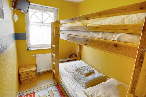 ツィングストにあるHampel, Fewo Vogelsang-Whg 1の黄色い部屋 窓付 二段ベッド2組