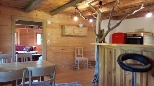 una sala da pranzo e una cucina in una baita di tronchi di Biohof Neihausmo a Böbing
