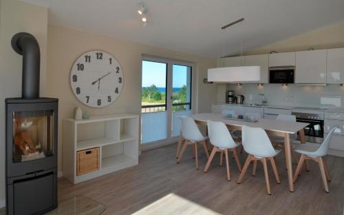 eine Küche mit einem Tisch und einer Uhr an der Wand in der Unterkunft Langeland in Kronsgaard