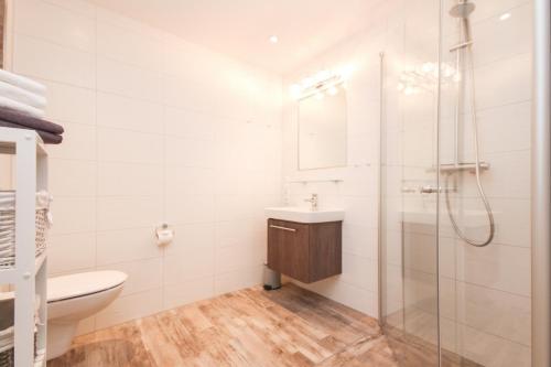 bagno con doccia, lavandino e servizi igienici di Ferienwohnung "Blinkfüür No25" a Krummhörn