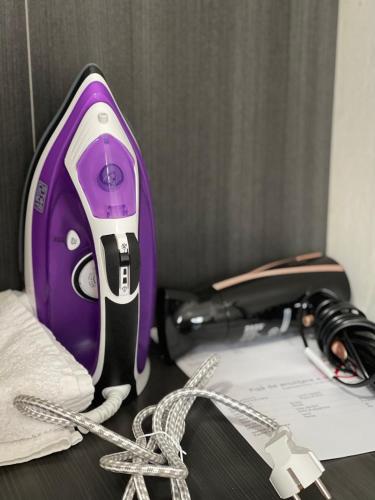 a purple and black hair dryer sitting on a table at Cozy Studio 1 Bedroom nearby Value Center Mall in Zalău