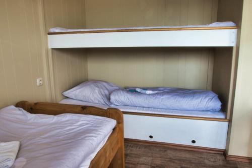 2 łóżka piętrowe w niewielkim pokoju z zapaleniem kręgosłupa, które polega na zapaleniu kręgosłupa w obiekcie Finnenhaus 3 w Lubece