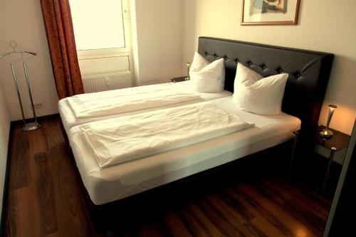sypialnia z dużym łóżkiem z białą pościelą w obiekcie Apartment 8 w mieście Wilhelmshaven