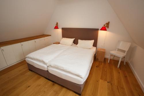 - une chambre avec un grand lit et une chaise dans l'établissement Stall, à Borgsum
