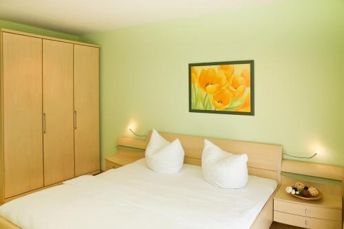 um quarto com uma cama branca e um quadro de flores em Ferienwohnung Oase102 em Kühlungsborn