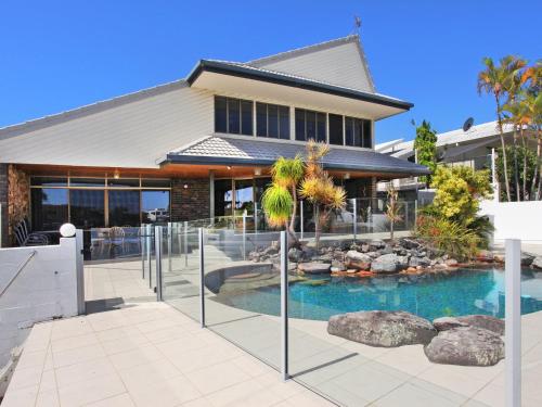 a house with a swimming pool in front of a house at Yulunga 20 in Mooloolaba