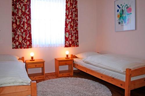 a bedroom with two beds and two candles on tables at "Landhaus Voss" Typ 2 Nr5 in Staberdorf