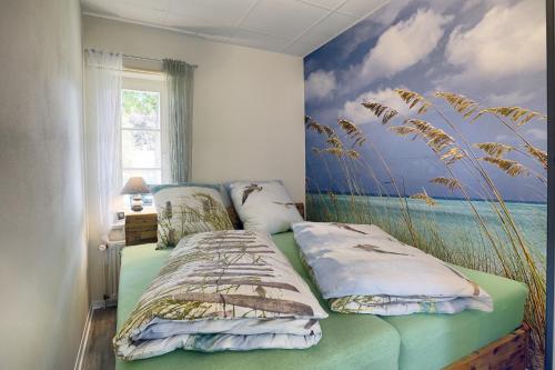 a bedroom with a bed and a painting of the ocean at Seelavie in Zingst