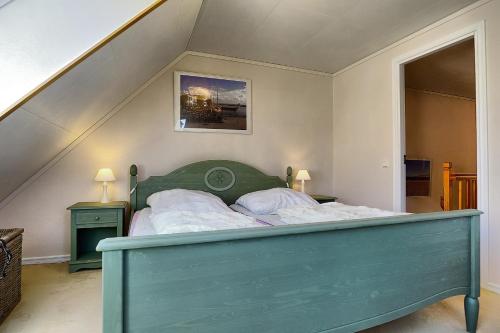 ツィングストにあるKäptn Blaubärの階段付きの部屋の緑色のベッド1台