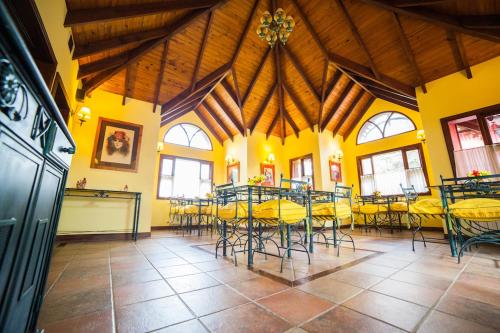 a large room with tables and chairs in a building at Hotel Campanilla in Ushuaia