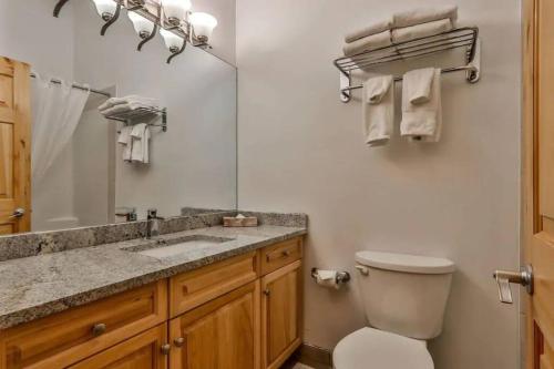 een badkamer met een toilet, een wastafel en een spiegel bij Banff Gate vacation townhouse in Canmore