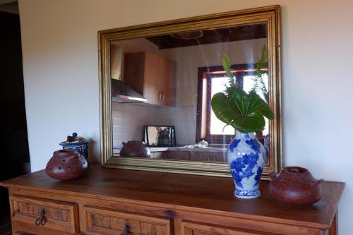 un vase assis au-dessus d'une commode devant un miroir dans l'établissement Complejo Rural Pajar de Bento, à Agulo