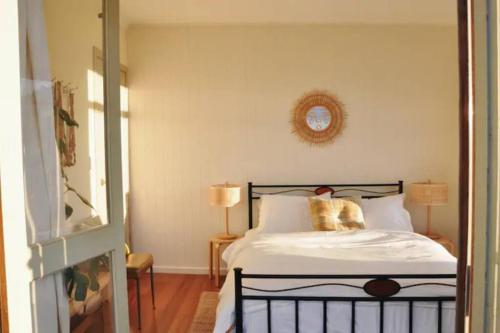a bedroom with a bed and a clock on the wall at The Shack at Skenes Creek in Apollo Bay