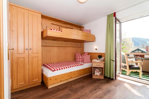 Cette petite chambre comprend des lits superposés et une fenêtre. dans l'établissement Riederstein, à Bad Wiessee