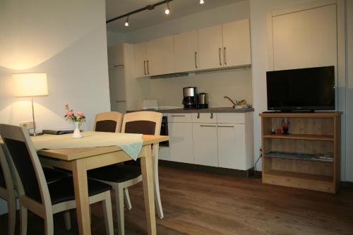 une cuisine et une salle à manger avec une table et une télévision dans l'établissement Riederstein, à Bad Wiessee