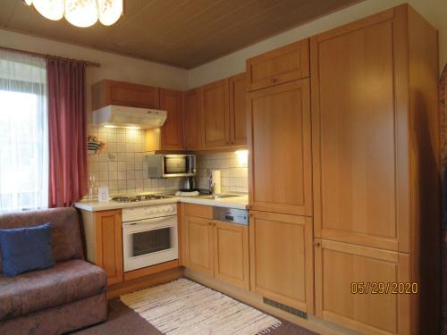 a kitchen with wooden cabinets and a couch in a room at Villa Löcker 3 in Mariapfarr