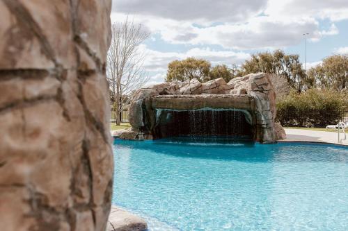 a swimming pool with a waterfall in a park at Tindarra Resort in Moama