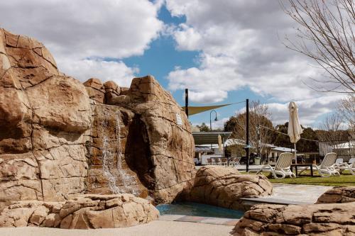 a rock waterfall in a pool in a park at Tindarra Resort in Moama