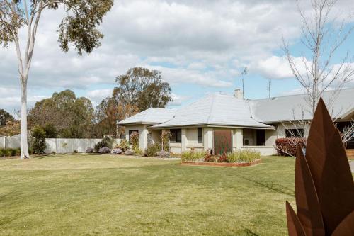 a white house with a large yard at Tindarra Resort in Moama