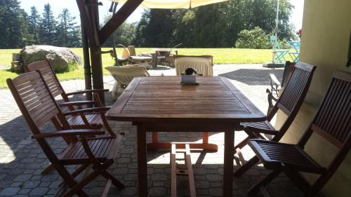 a wooden table and chairs on a patio at Chalet "Aisha-Les Chevreuils" in Corbeyrier