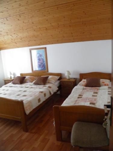 a bedroom with two beds and a wooden ceiling at House Janja Plitvice in Seliste Dreznicko