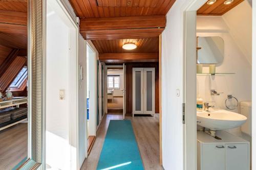 um corredor com uma casa de banho com um lavatório e um espelho em Haus zum Seiltänzer - Oberdeck em Eckernförde