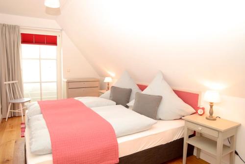 ヴィーク・アウフ・フェールにあるHaus Sturmmöwe Waldstraßeのベッドルーム(白いベッド1台、赤い毛布付)