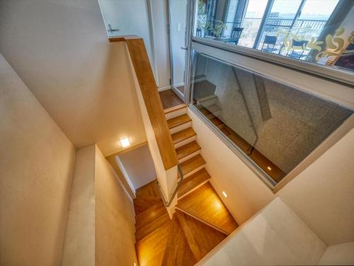 a staircase in a house with a glass window at Seaside Condominium Rana Chatan in Chatan