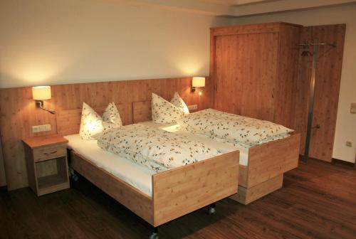 een slaapkamer met een groot bed met een houten hoofdeinde bij Koglkopf in Bad Wiessee