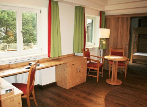 een kamer met een tafel en stoelen en een raam bij Koglkopf in Bad Wiessee