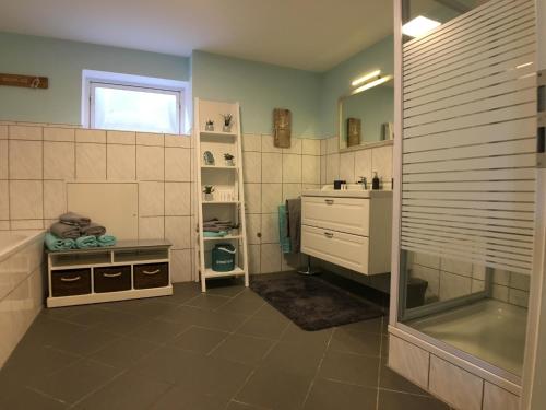 een badkamer met een douche, een wastafel en een bad bij Knudsens Koje in Windeby