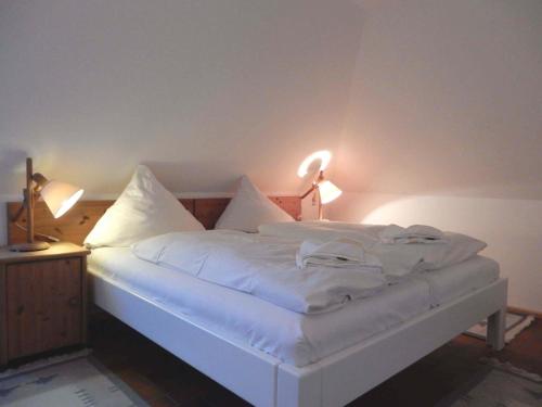 Un dormitorio con una cama blanca con dos luces. en Resi E06 en Prerow