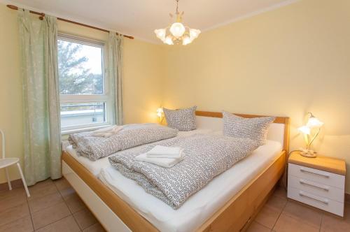 a bedroom with a bed and a window at Ostseeresidenz - Whg 29 in Zingst