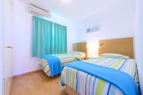 2 camas individuales en una habitación con ventana en Apartamentos Loma Estrella en Mogán