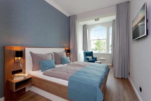 a bedroom with a large bed and a window at Villa Seeblick "Wolgastsee" in Ahlbeck