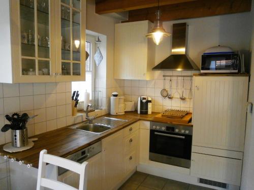 eine Küche mit einer Spüle und einem Herd in der Unterkunft Dat Onnens Hus - Burhave 03 in Butjadingen