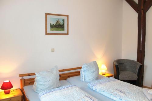 a bedroom with two beds and a picture on the wall at "Hof Triangel - Whg 2" - Bauernhofurlaub in Riepsdorf