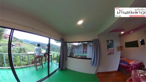 twee personen in een kamer met een balkon bij Baan Chomdao Phu Thap Buek in Phetchabun