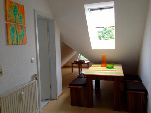 een trapkamer met een tafel en een raam bij Ferienwohnung Ertl - 14518 in Petersdorf auf Fehmarn