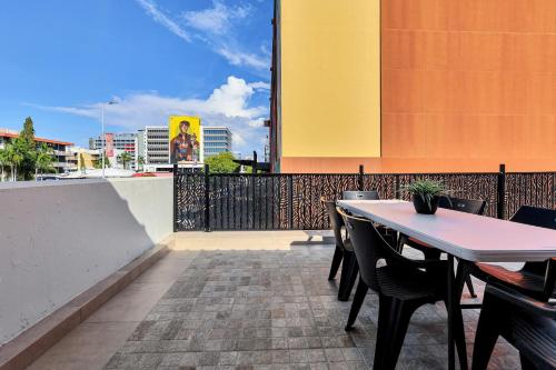 a patio with a table and chairs on a balcony at Capitanos in Darwin