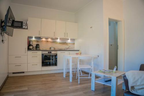a kitchen with white cabinets and a table in a room at Scheune 9 in Gollendorf