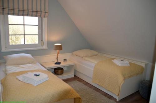 1 dormitorio con 2 camas y ventana en Maisfeld Wohnung, en Wyk auf Föhr