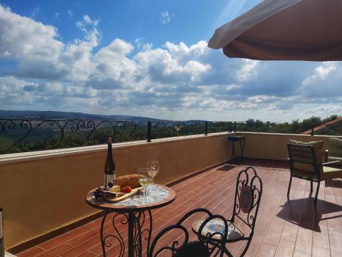 a table and chairs on a balcony with a bottle of wine at Castello Panorama in Abirim
