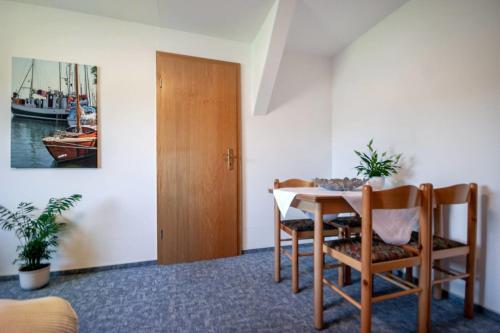 ein Esszimmer mit einem Tisch, Stühlen und einer Tür in der Unterkunft Knusthof - Wohnung 3 in Albertsdorf