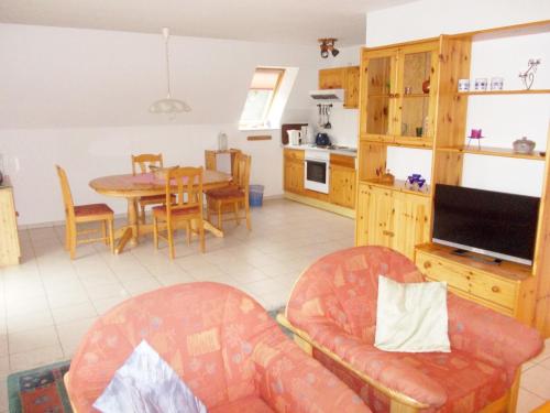 eine Küche und ein Wohnzimmer mit einem Tisch und Stühlen in der Unterkunft Finnhäuser am Vogelpark - Haus Lisa in Marlow