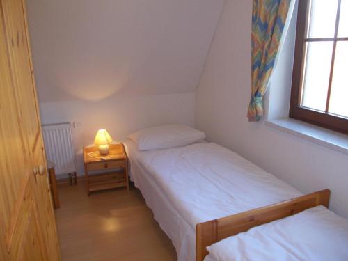 馬爾洛的住宿－Finnhäuser am Vogelpark - Haus Lisa，一间卧室设有两张床和一张桌子上的台灯。